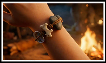 Wrist wearing a bone, shell and stone cord bracelet by a campfire