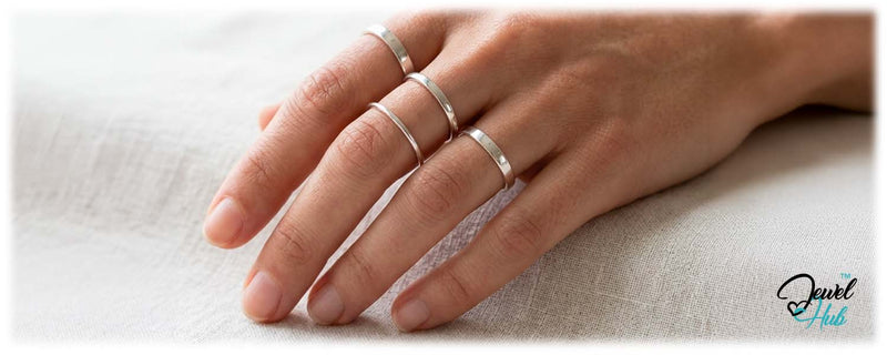 Multiple silver rings balanced on one hand for calm, clear styling