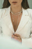 person wearing silver necklace and white robe