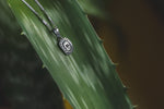 a close up of a leaf with a necklace on it