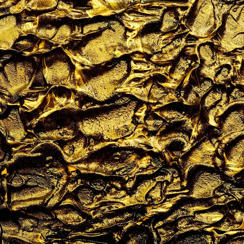 a close up of a textured surface with gold paint