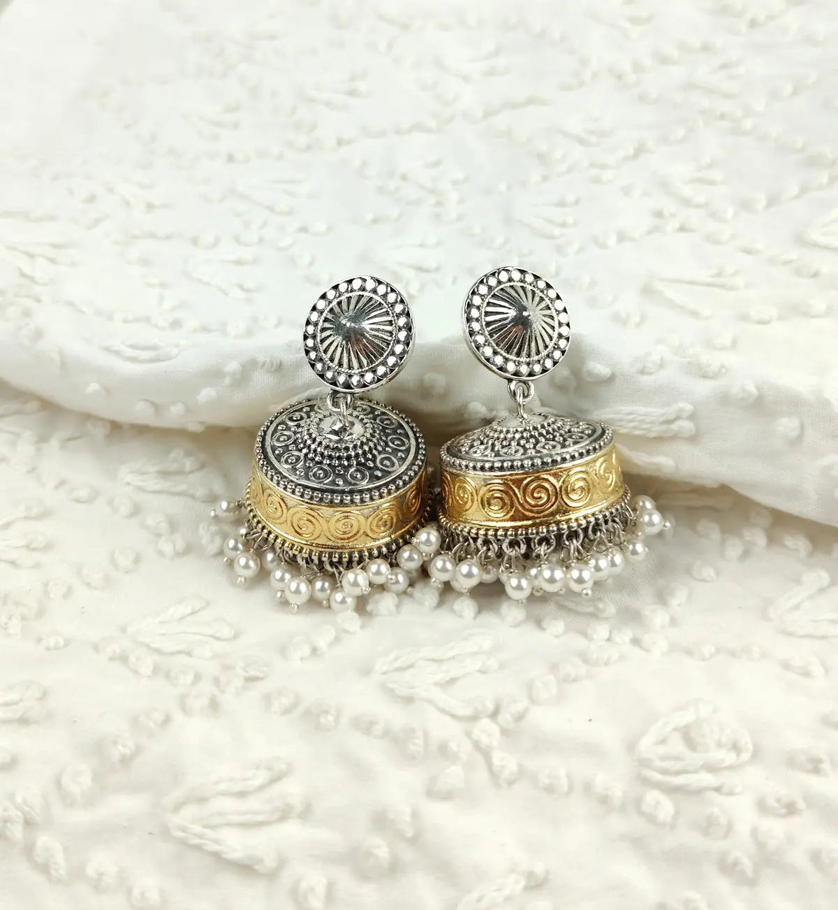 a pair of silver and gold earrings