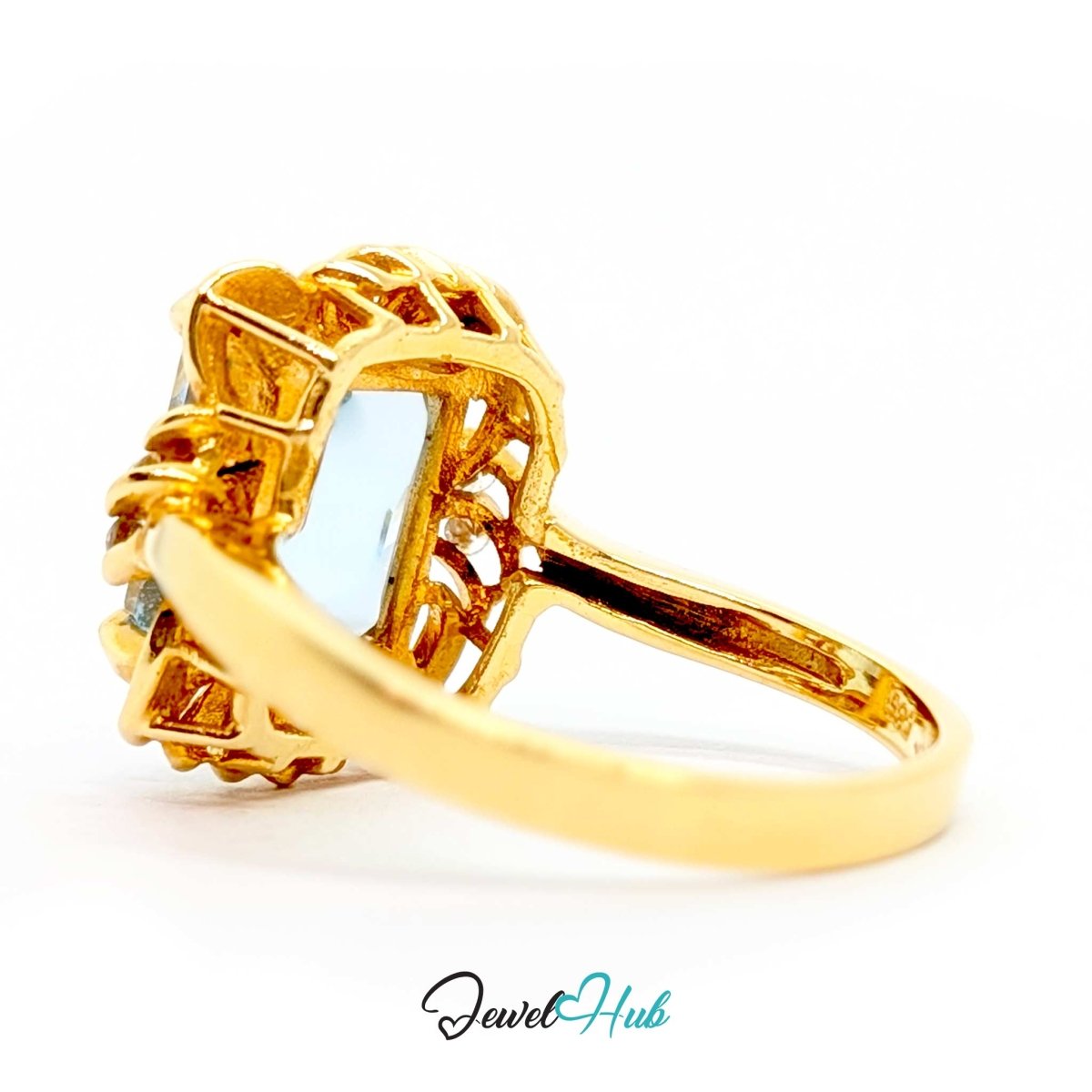A 14k gold ring with a large light blue rectangular gemstone, featuring an intricate openwork filigree top and a polished band, shown on a white background with a 'JewelHub' watermark.