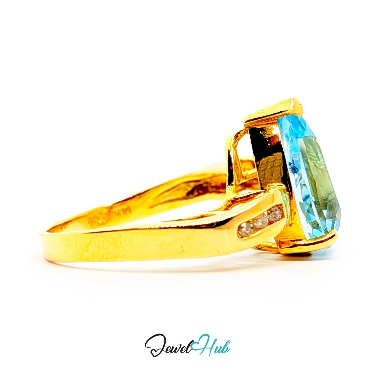 A 14k yellow gold ring featuring a large rectangular blue topaz gemstone and a small inset row of clear stones on the shank, shown against a plain white background with a 'JewelHub' watermark at the bottom.