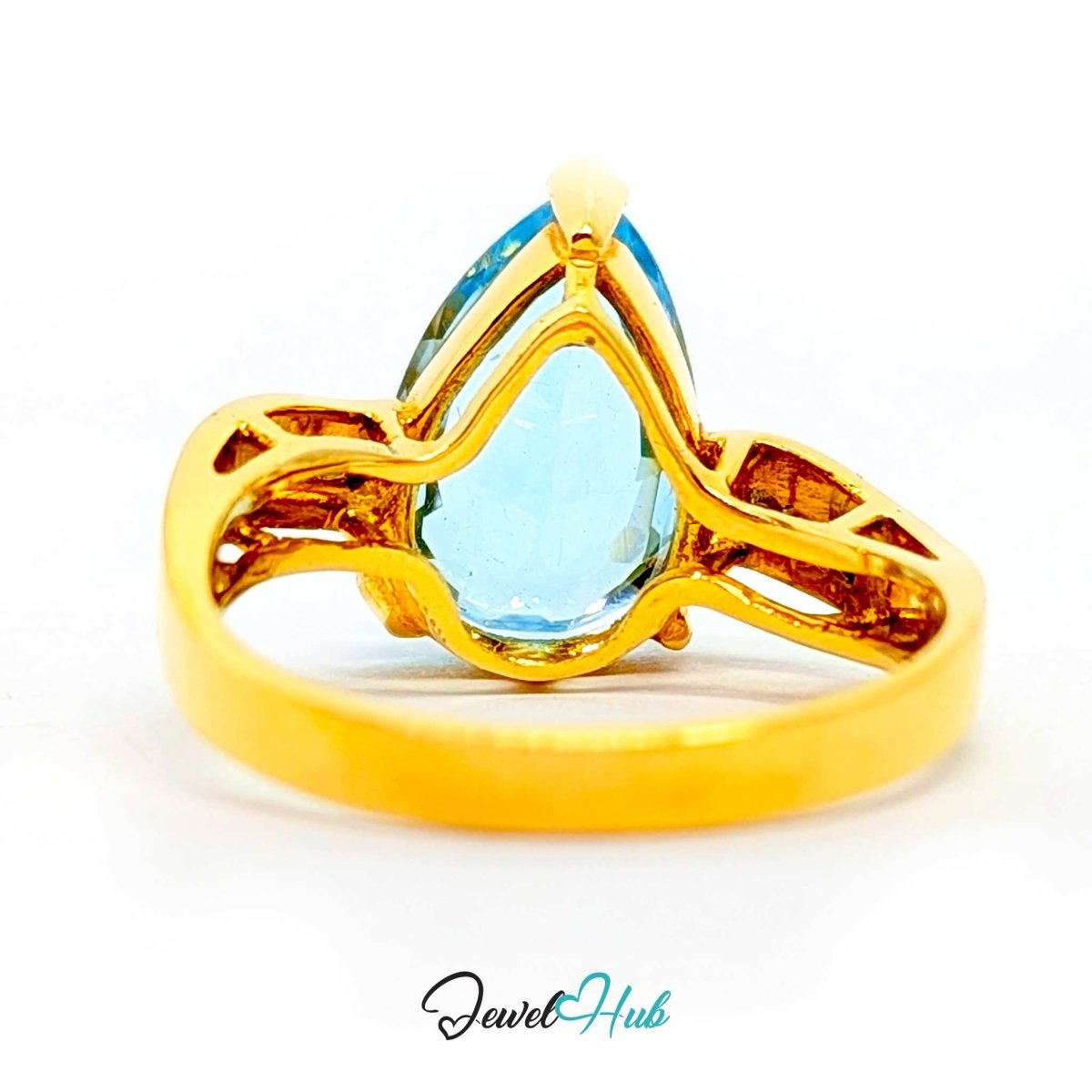A 14k gold ring featuring a large, faceted light blue teardrop-shaped gemstone, photographed on a clean white background with a 'JewelHub' watermark at the bottom.