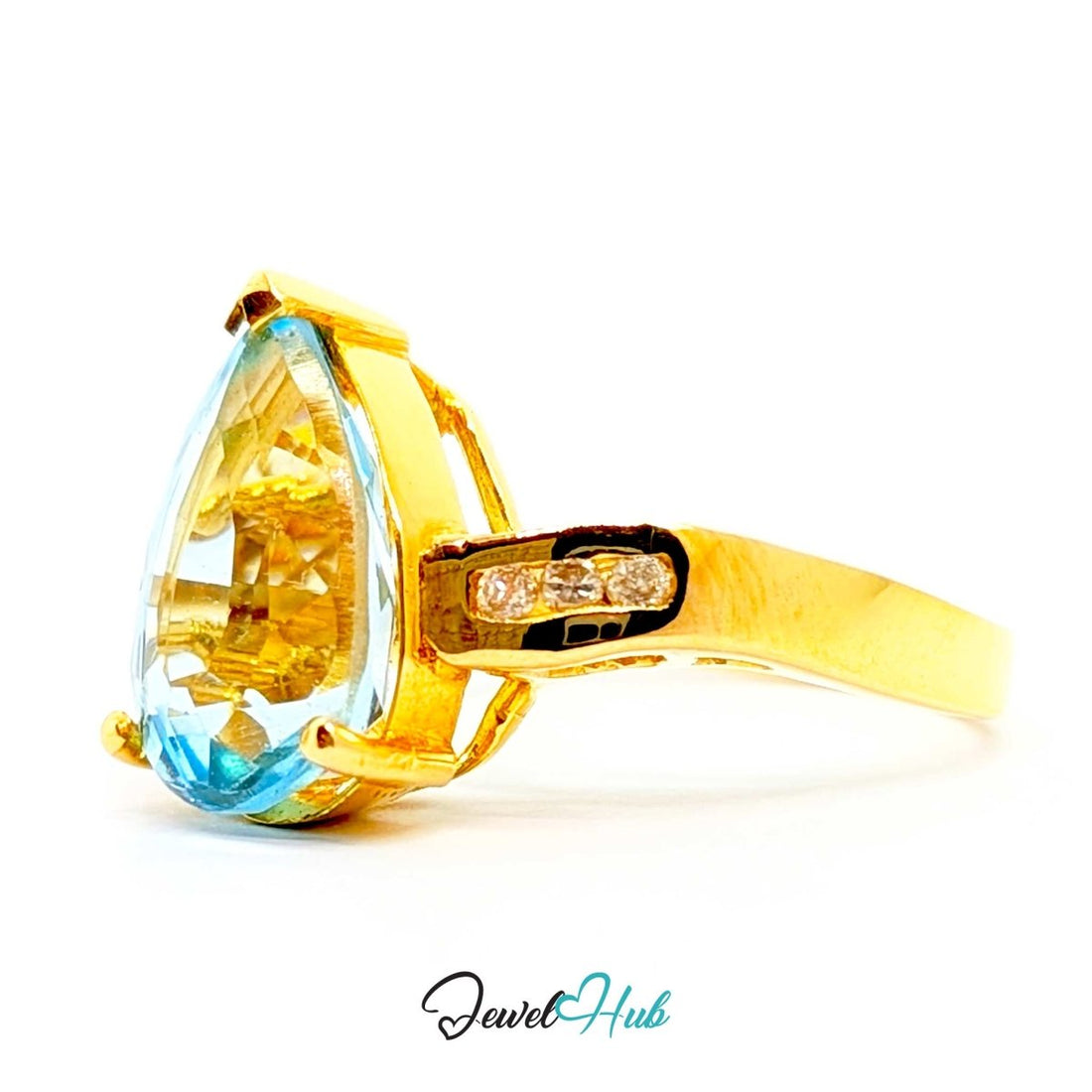 A 14k gold ring featuring a large pear-cut light blue gemstone in a prong setting, with small clear accent stones on the band, shown on a white background with a JewelHub watermark.