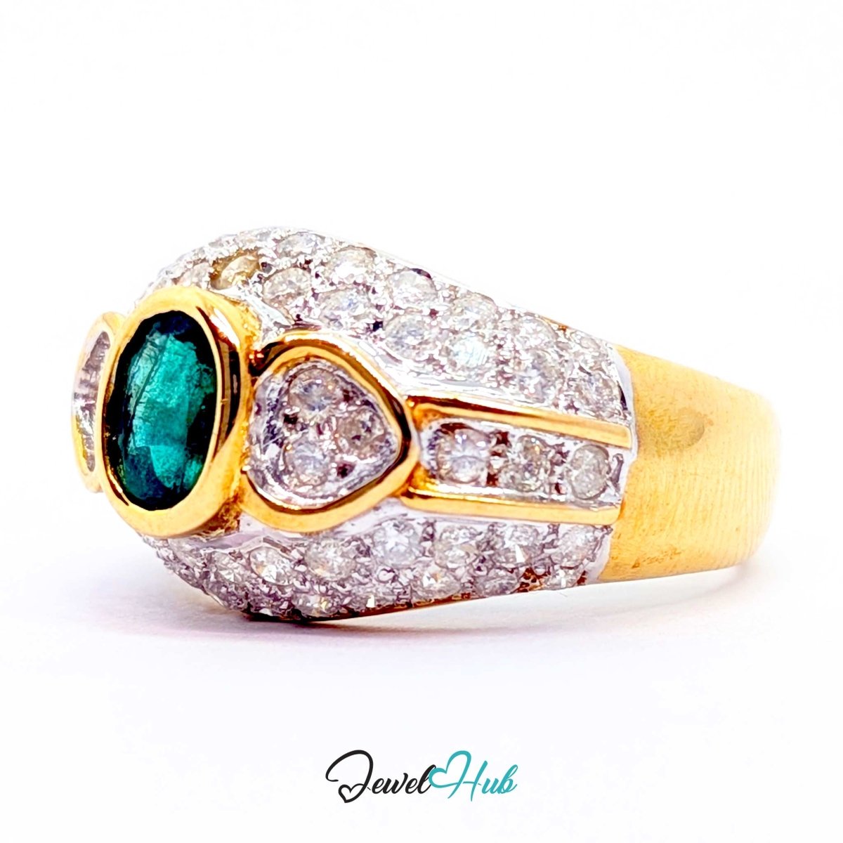 A 14k yellow gold ring with a large oval green emerald-cut center stone and pavé-set clear stones, photographed on a white background with a JewelryHub watermark.