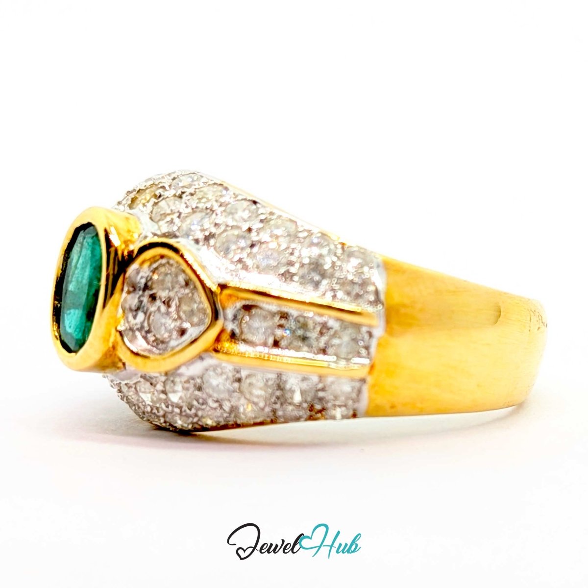 A 14k yellow gold ring featuring a large oval green emerald-cut gemstone on the side, accented by pavé diamonds on the upper half and a smooth gold band.