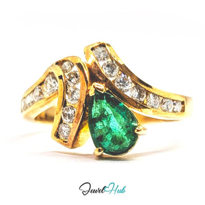 A 14k gold ring featuring a large pear-cut green emerald center stone and curved gold bands set with small clear stones, shown on a white background with a JewelHub watermark.