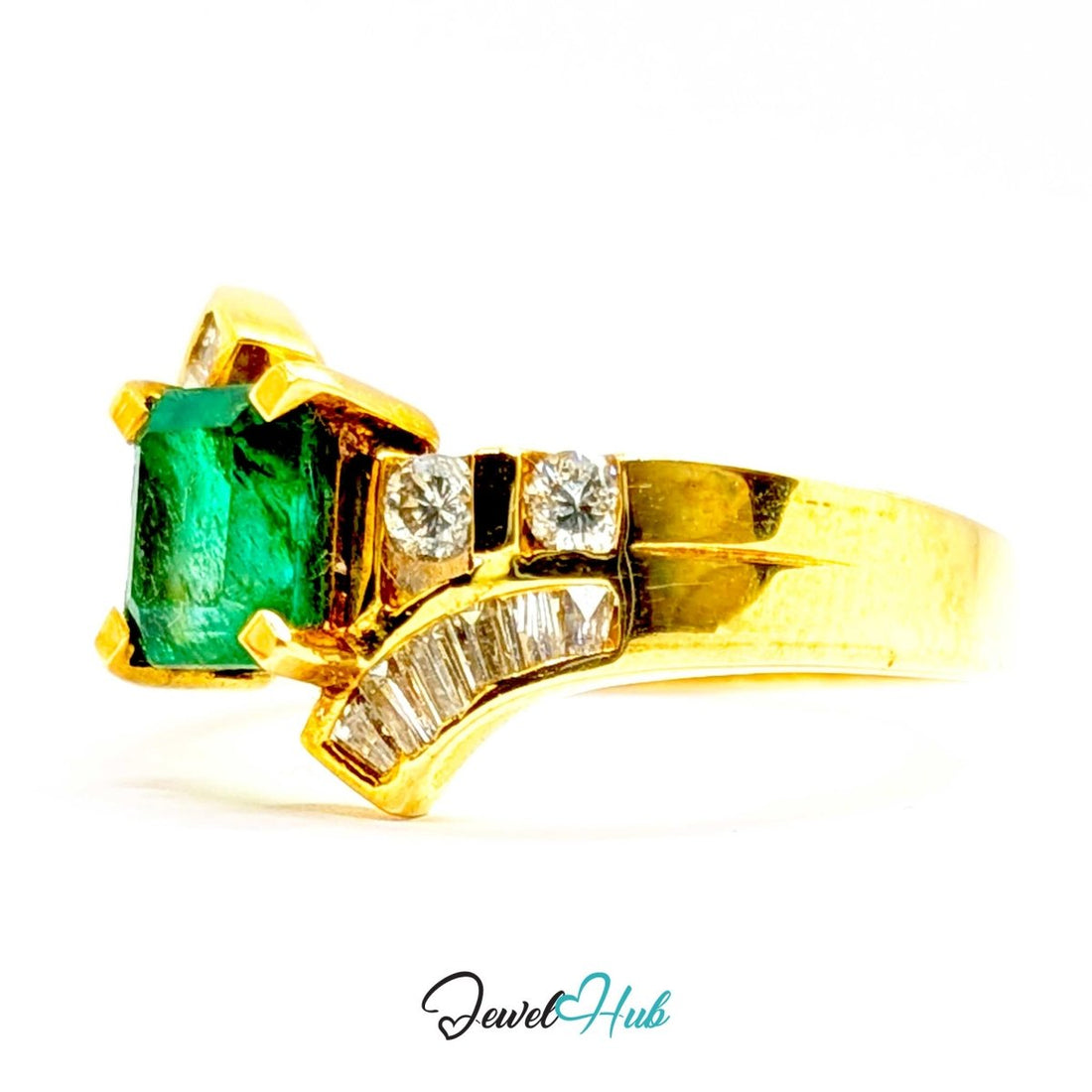 A 14k yellow gold ring featuring a rectangular green emerald-cut center stone and baguette-cut clear stones on curved side bands, shown on a white background with a JewelHub watermark.