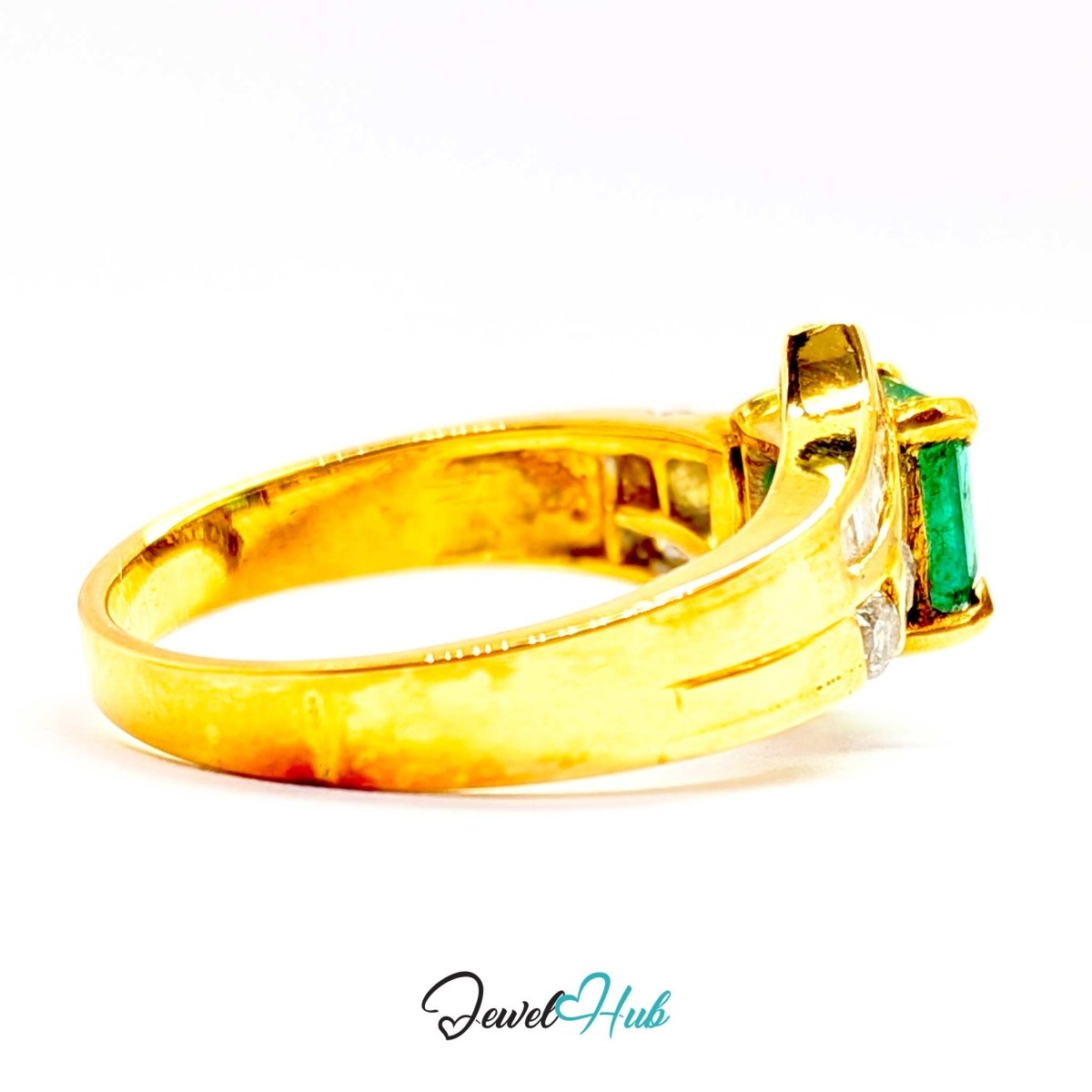 A 14k yellow gold ring featuring a rectangular green emerald-cut gemstone and a small clear accent stone, shown on a white background with a 'JewelHub' watermark at the bottom.