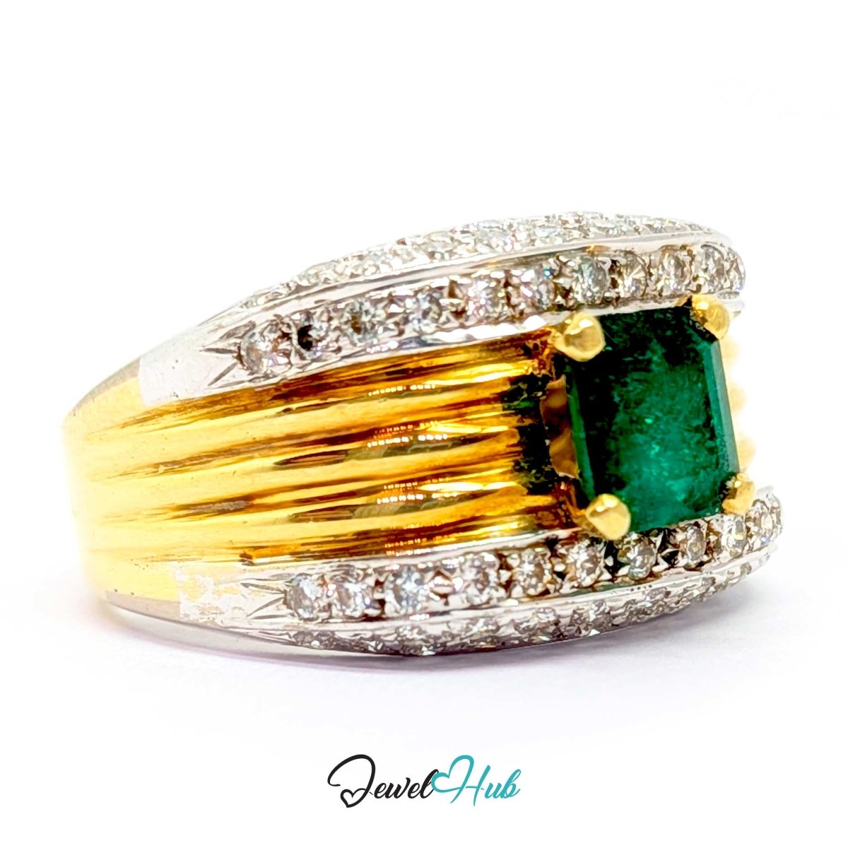 A yellow 14k gold and white gold ring featuring a rectangular green emerald-cut center stone surrounded by small clear stones, set on a white background with a JewelryHub watermark.