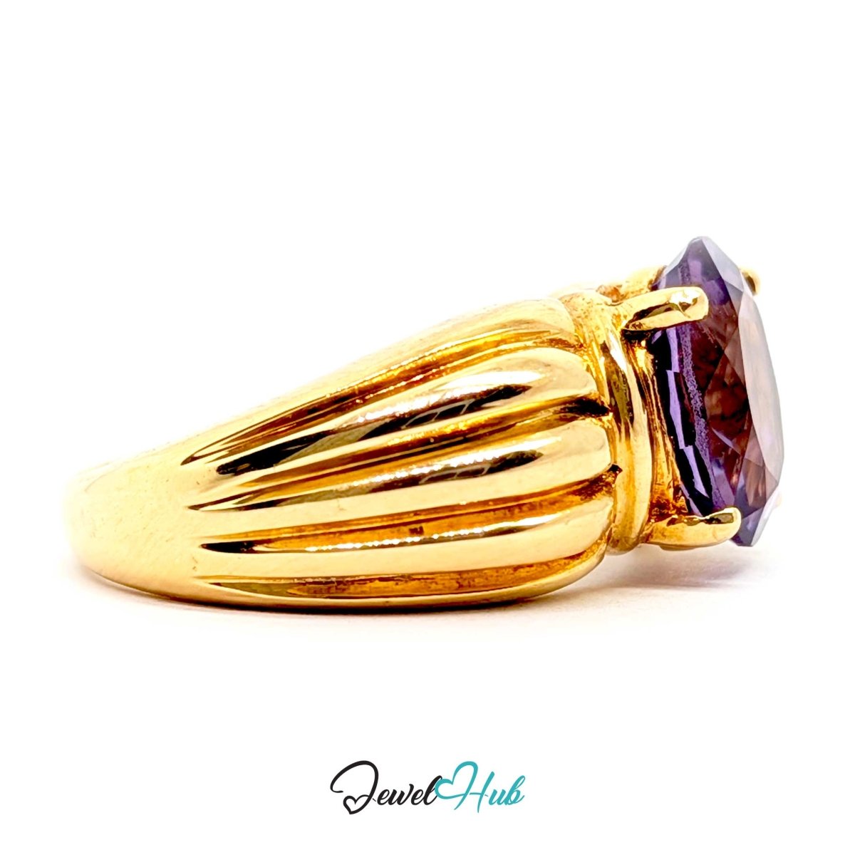 A 14k gold ring featuring a large, faceted oval purple gemstone in a prong setting, shown against a plain white background with a 'JewelHub' watermark at the bottom.
