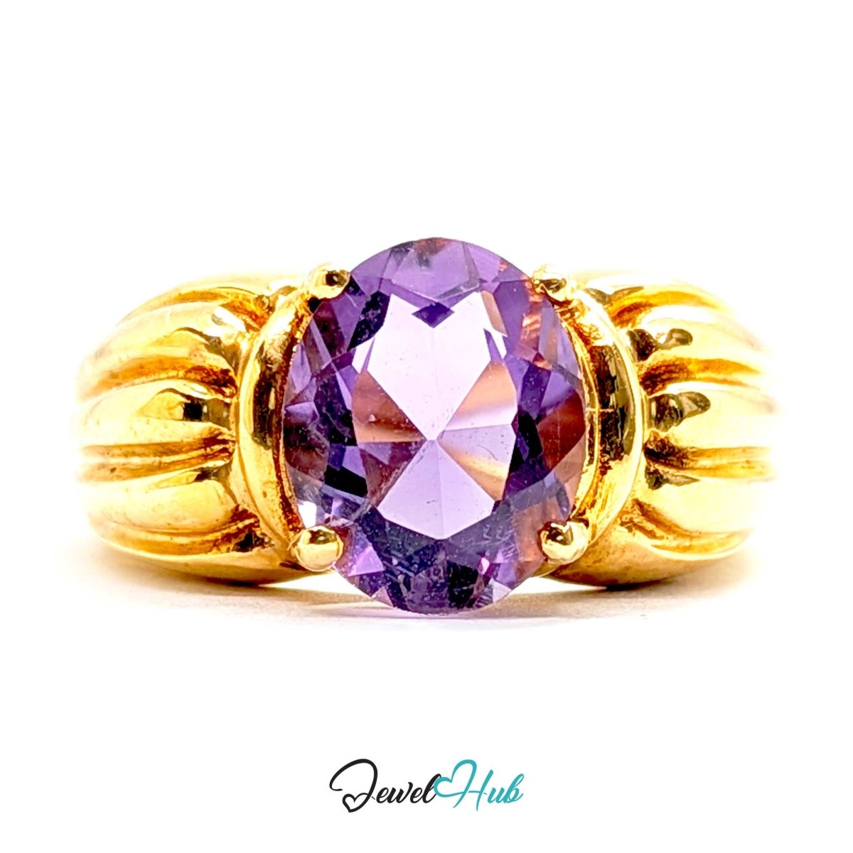 A 14k yellow gold ring featuring a large, faceted oval-cut purple amethyst gemstone in a prong setting, with decorative ribbed gold sides, shown on a white background with a 'JewelHub' watermark at the bottom.