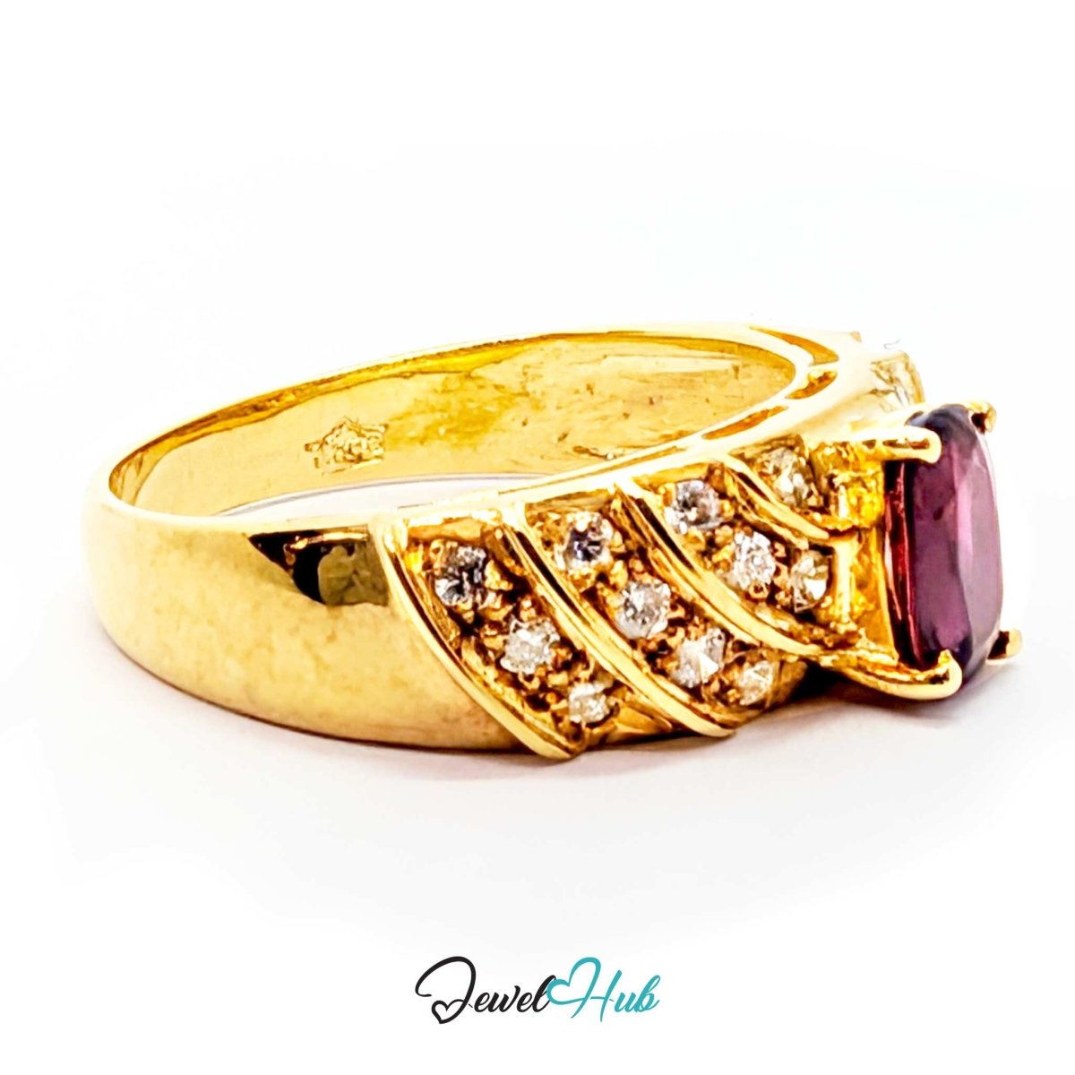 A yellow 14k gold ring with a large oval purple gemstone and smaller clear accent stones, shown on a white background with a JewelryHub watermark.