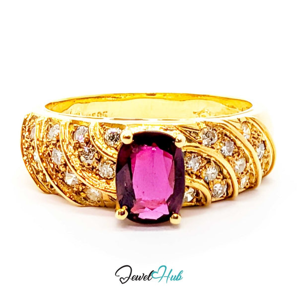 A yellow 14k gold ring featuring a large oval-cut pink gemstone in the center, surrounded by smaller clear stones and textured gold bands, shown on a white background with a JewelryHub watermark.