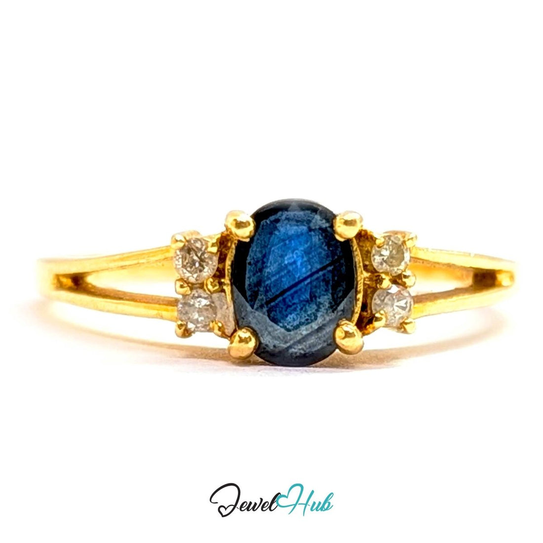 A yellow 14k gold ring featuring a central oval-cut deep blue labradorite gemstone, flanked by two small round-cut clear accent stones on each side. The ring is photographed on a clean white background with a 'JewelHub' watermark at the bottom.
