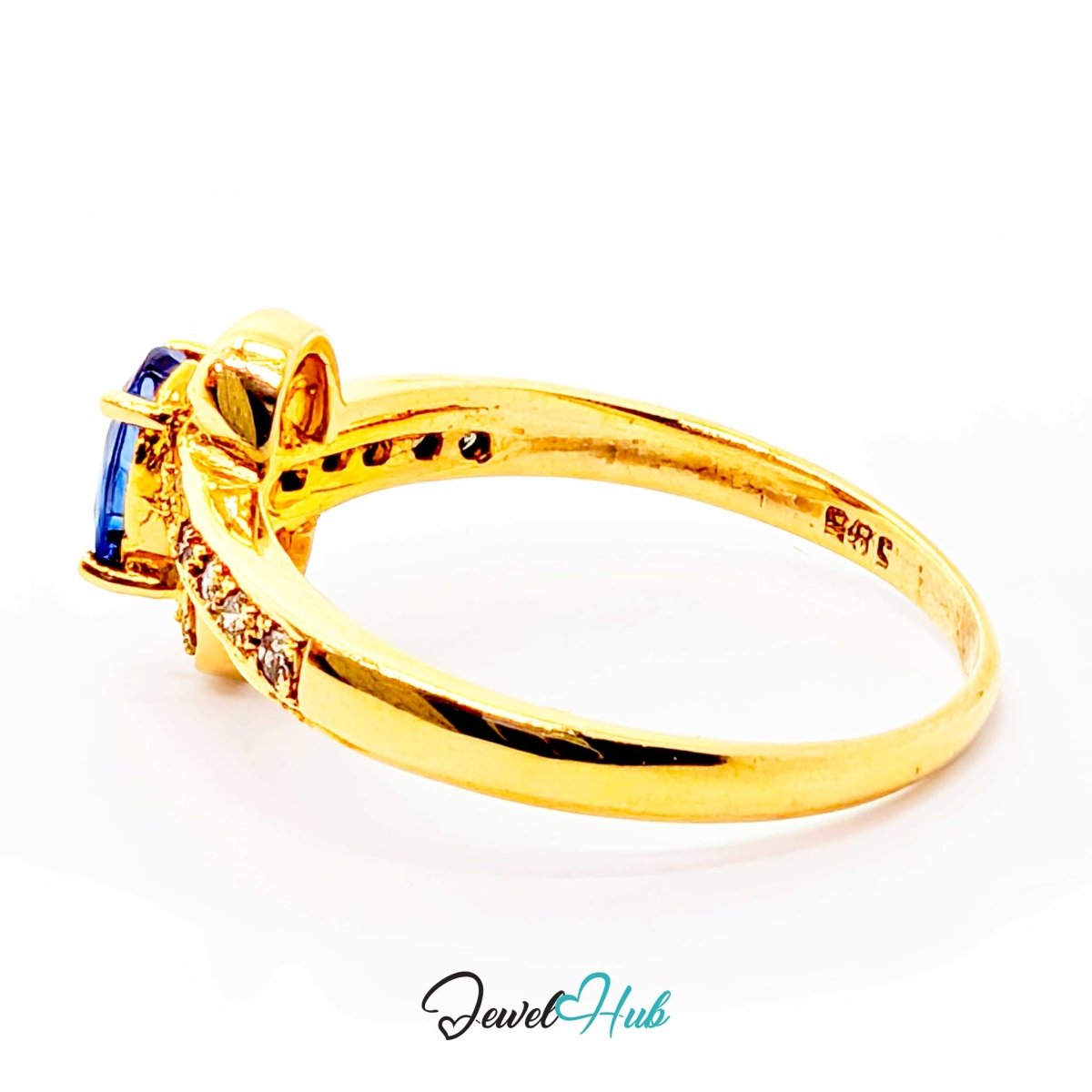 A yellow 14k gold ring with a blue rectangular gemstone and small clear accent stones, shown on a white background with a JewelHub watermark.