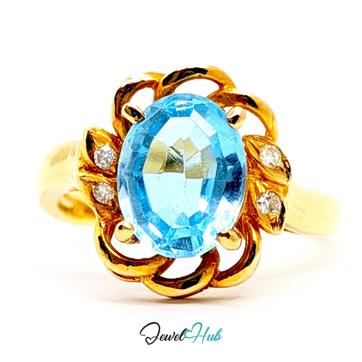 A yellow 14k gold ring featuring an oval-cut light blue topaz center stone and small round diamond accents on the sides, set against a plain white background with a 'JewelHub' watermark at the bottom.