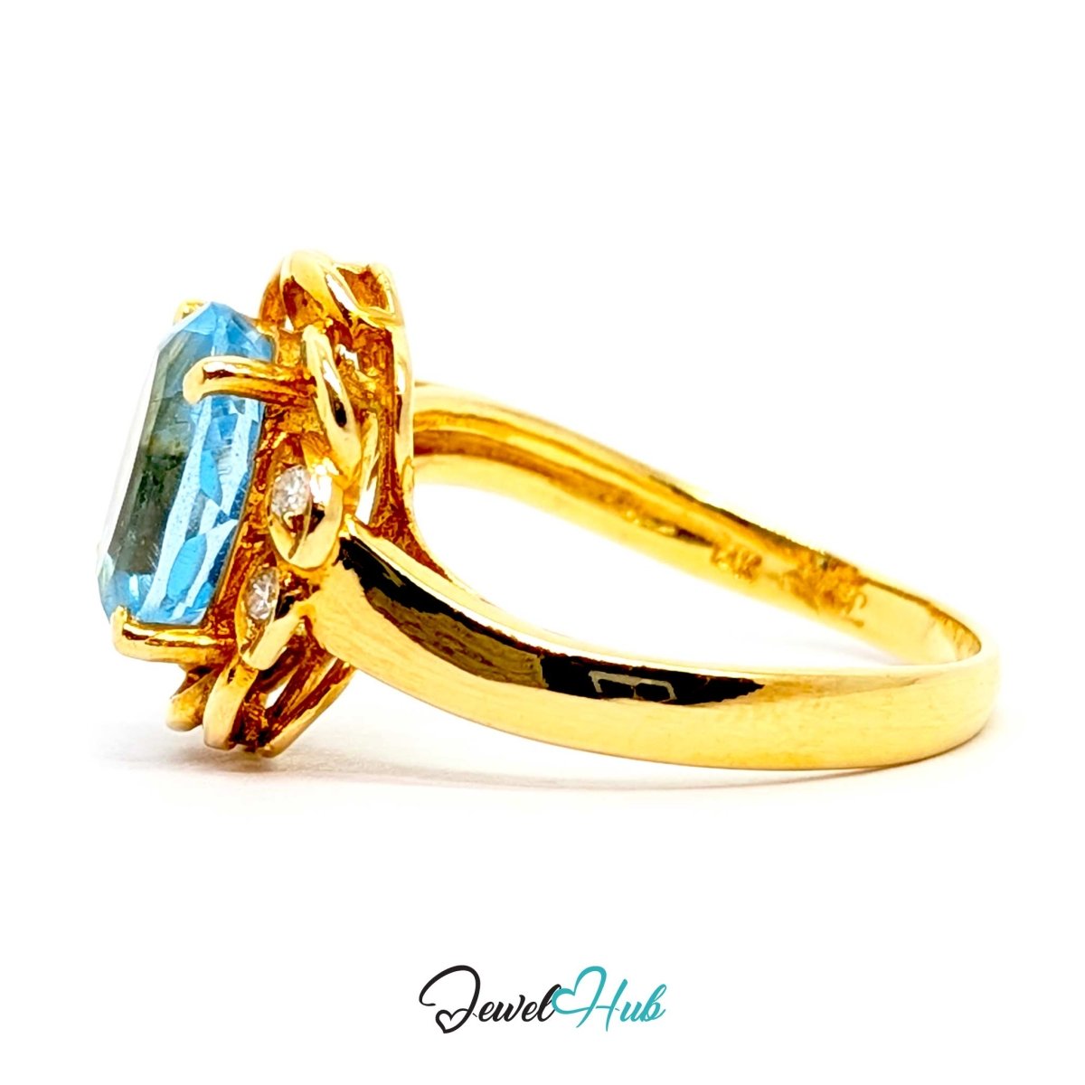 A yellow 14k gold ring featuring a rectangular light blue gemstone and small clear accent stones, shown on a plain white background with a JewelHub watermark at the bottom.