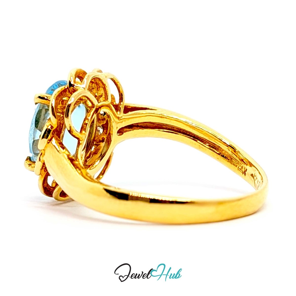 A yellow 14k gold ring featuring a decorative openwork crown-like setting with a light blue oval gemstone, shown on a white background with a JewelryHub watermark.