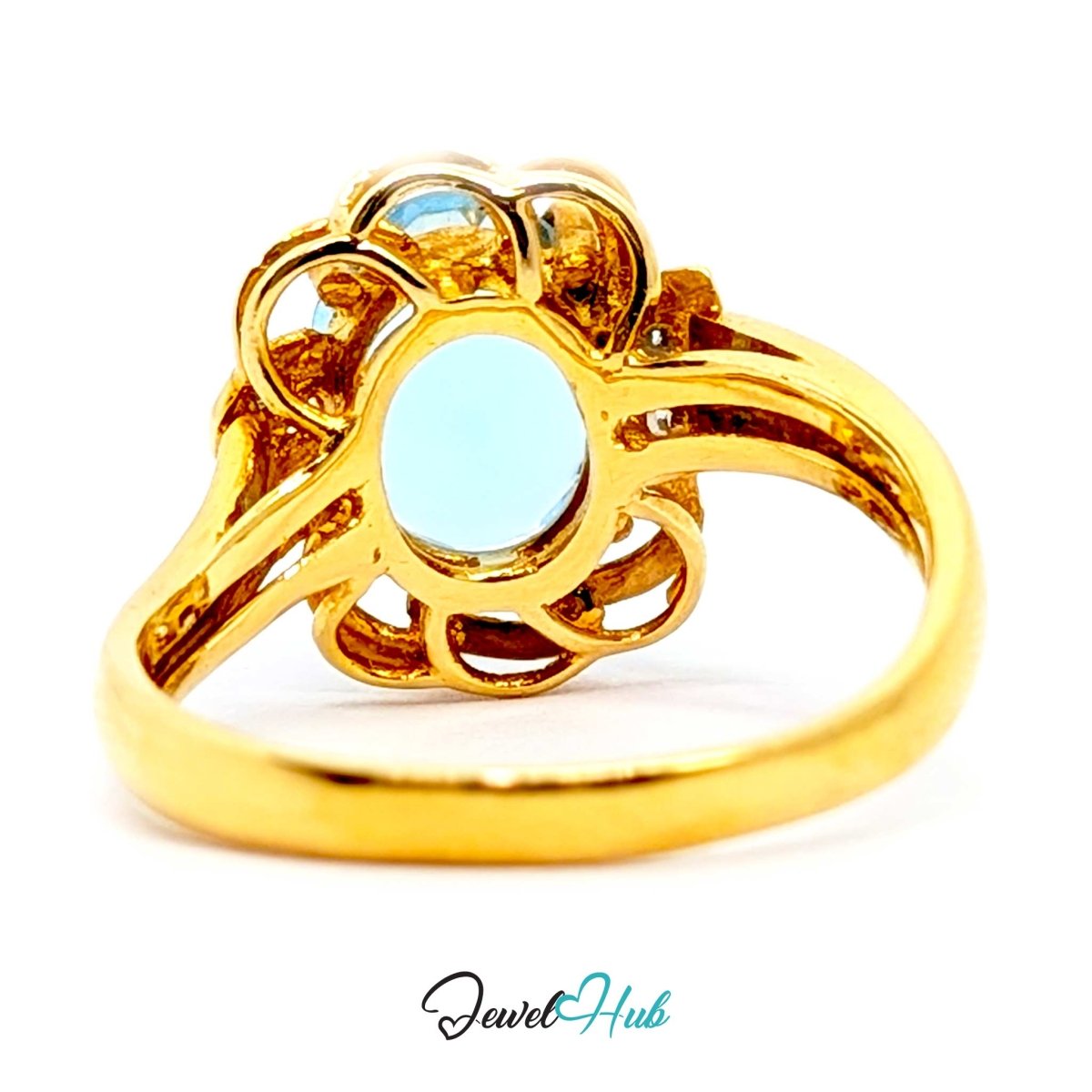 A yellow 14k gold ring featuring a large oval light blue gemstone in an ornate openwork setting, shown on a white background with a JewelryHub watermark.