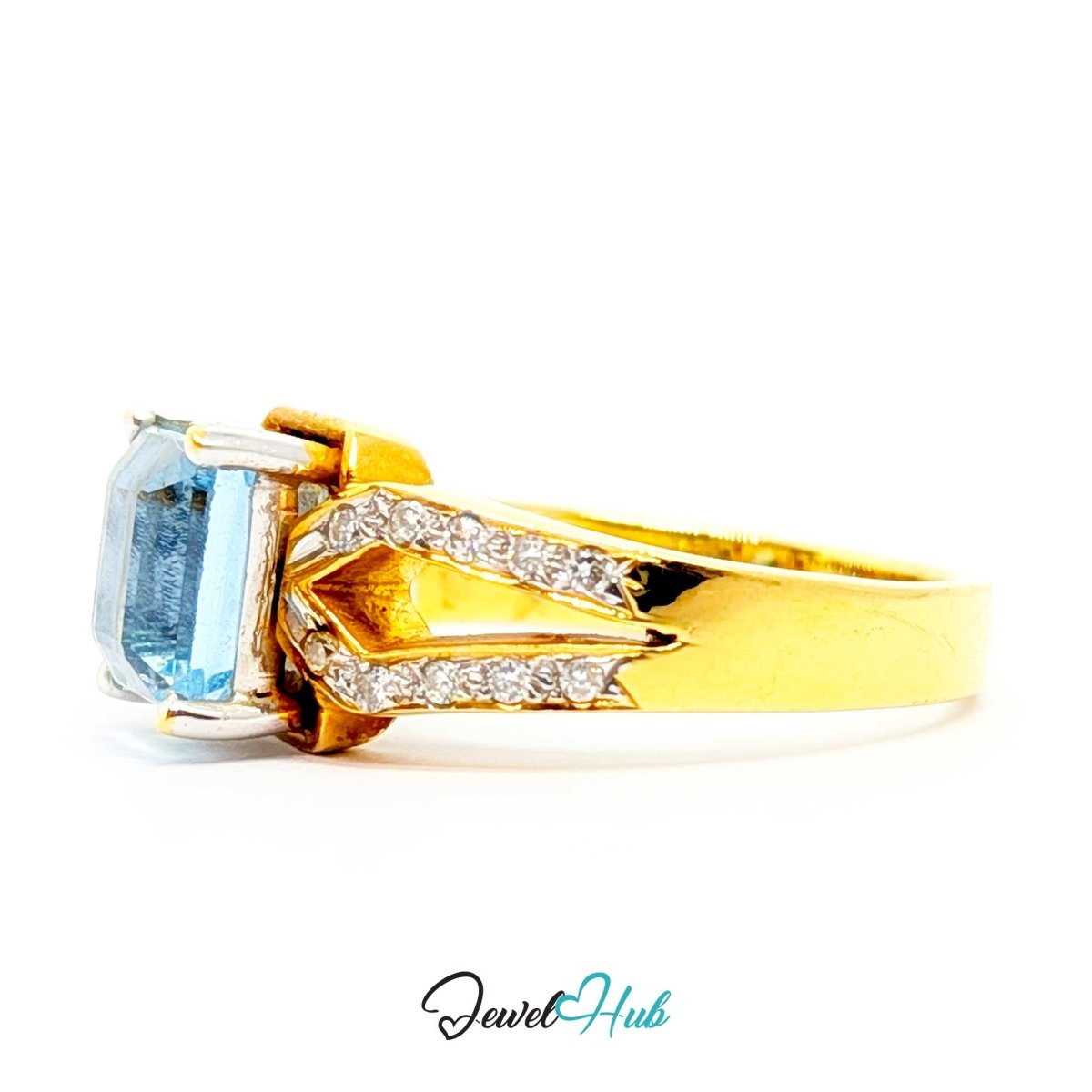 A 18k yellow gold ring featuring a rectangular light blue gemstone and pavé-set clear stones, shown on a white background with a 'JewelHub' watermark.