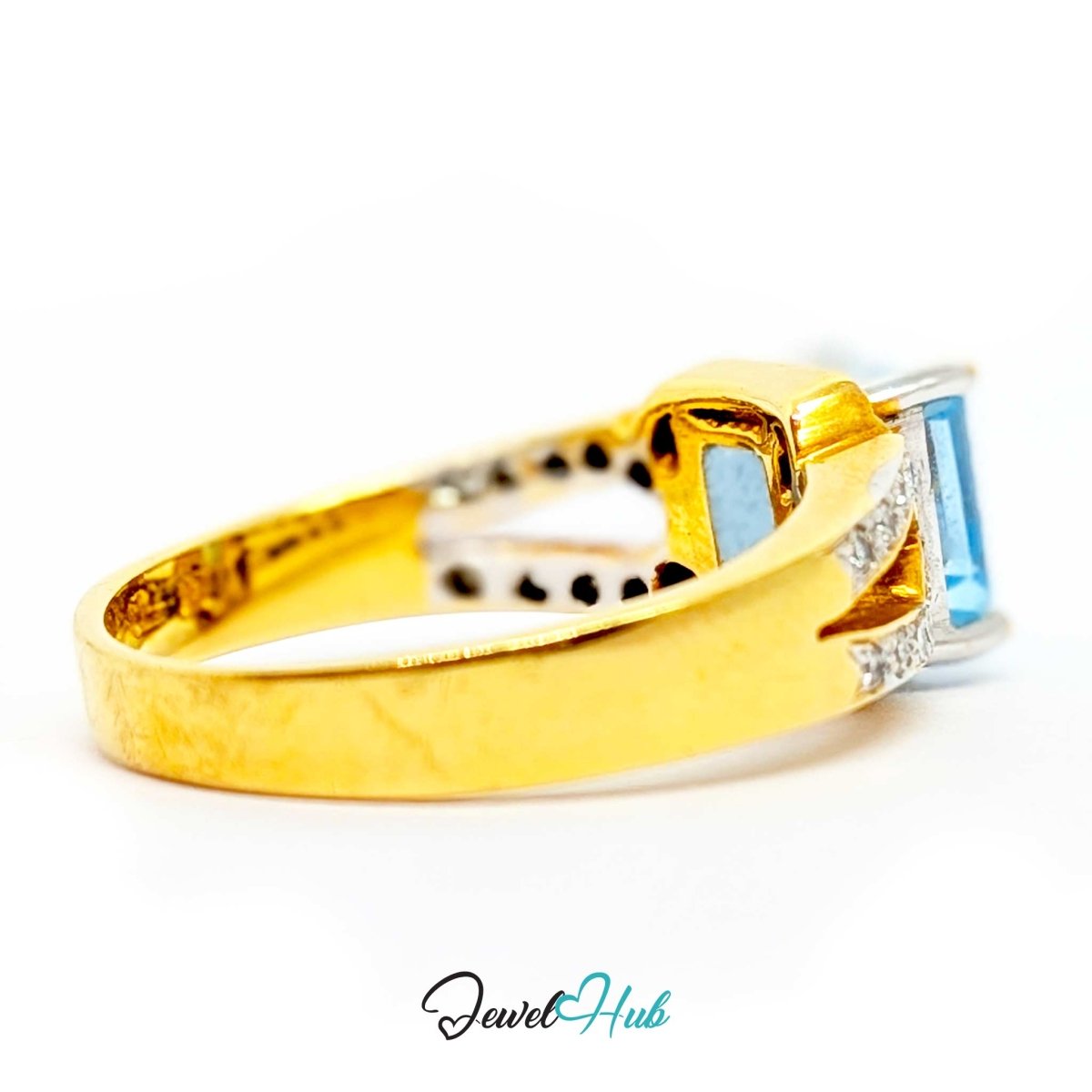A 18k yellow gold ring with a rectangular light blue gemstone and small clear accent stones, shown on a white background with a JewelHub watermark.