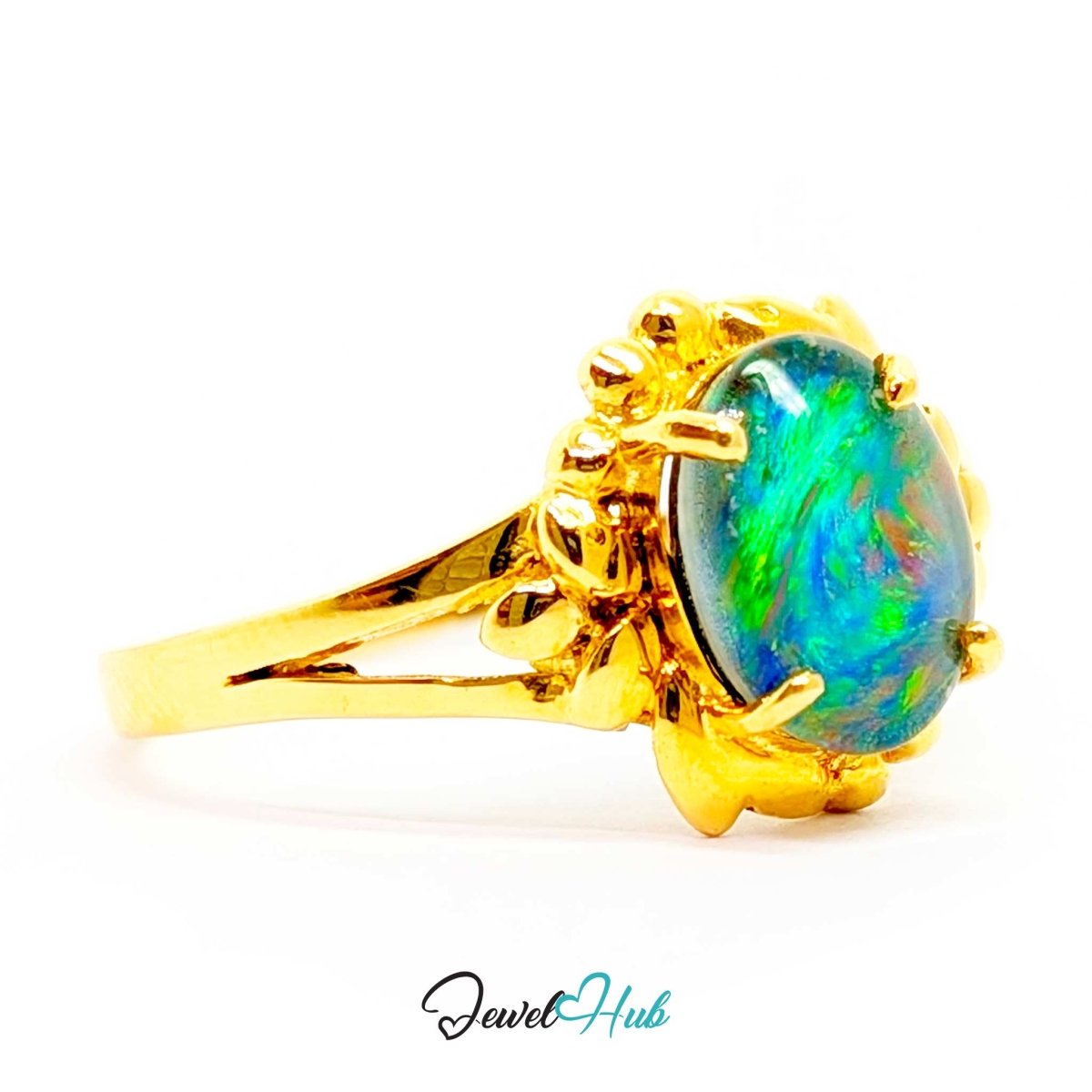 A 18k yellow gold ring featuring an oval cabochon opal gemstone with vibrant blue, green, and orange play-of-color, set in a decorative gold bezel on a white background.