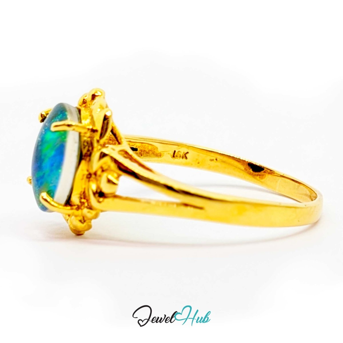 A 18k yellow gold ring featuring an oval cabochon opal gemstone with vibrant blue and green play-of-color, set in a claw-style prong. The ring is photographed on a clean white background with a 'JewelHub' watermark at the bottom.