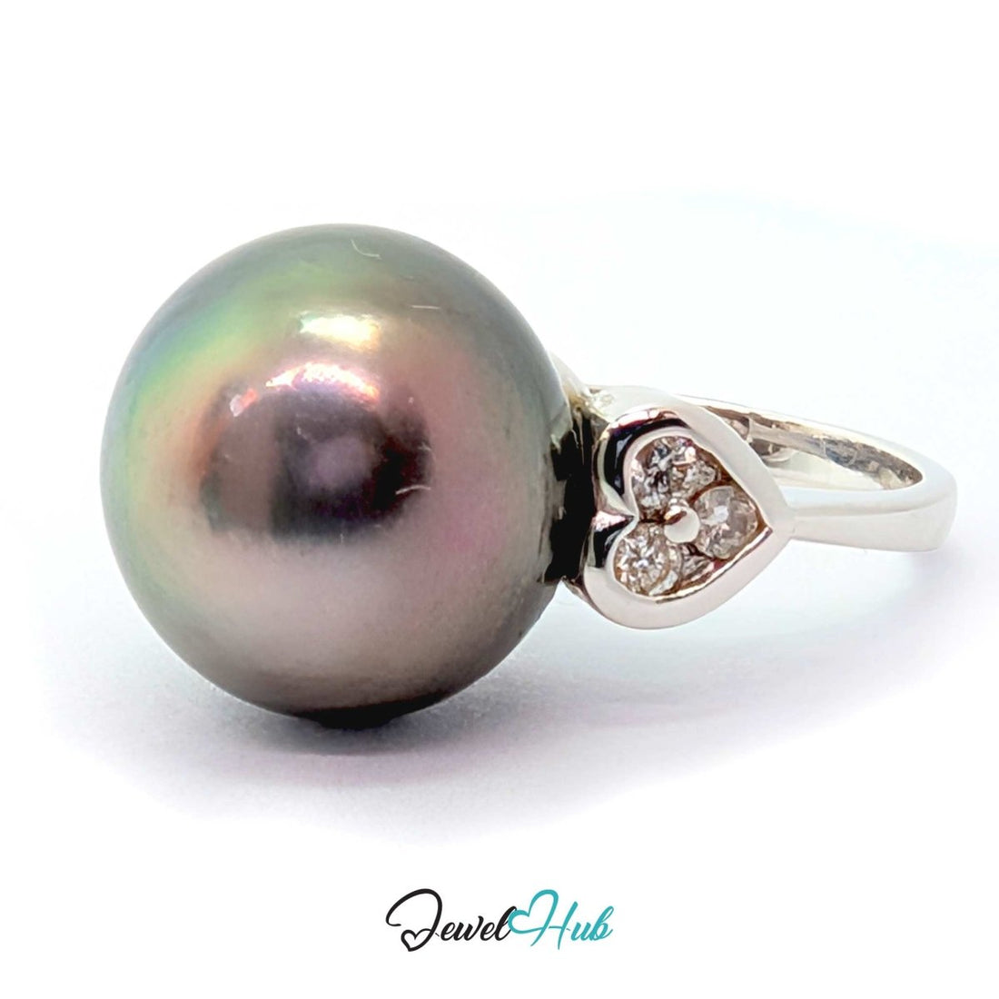 A round dark gray pearl ring with a 18k white gold  setting featuring small clear stones on each side, shown on a white background with a JewelryHub watermark.
