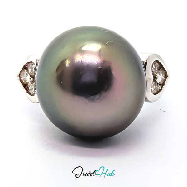 A round dark gray pearl ring with a 18k white gold  setting featuring small clear stones on each side, shown on a white background with a JewelryHub watermark.
