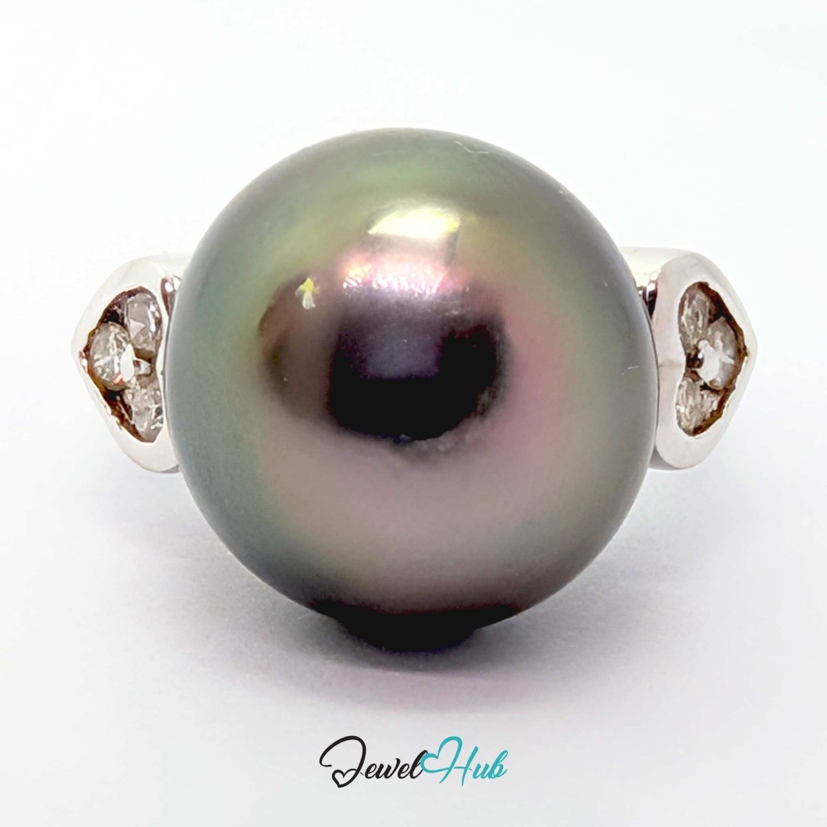 A round black pearl ring with a 18k white gold setting featuring small clear stones on each side, shown on a white background with a JewelryHub watermark.