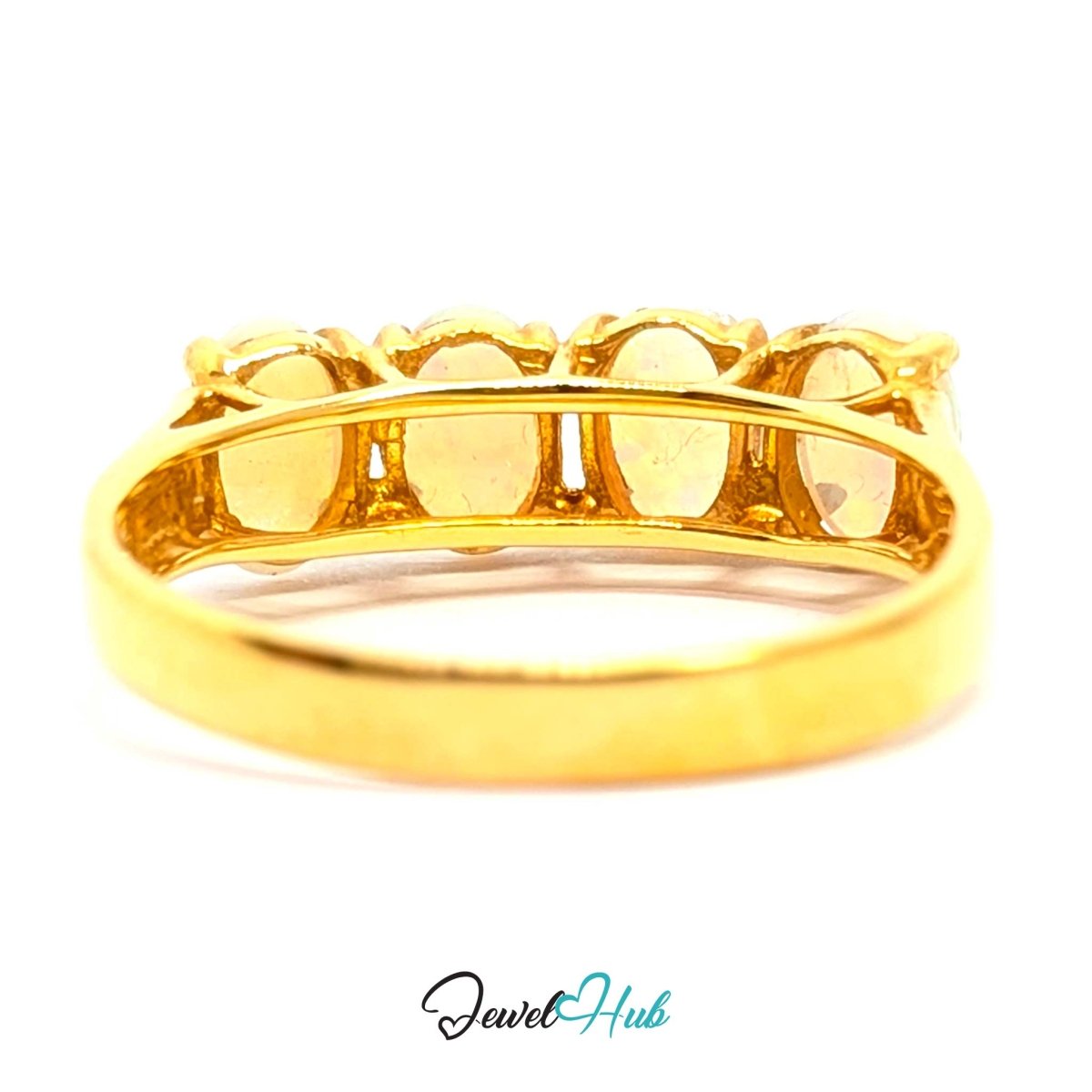 A yellow 18k gold ring with five oval-cut clear gemstones in a row, shown from a side angle on a white background with a 'JewelHub' watermark at the bottom.