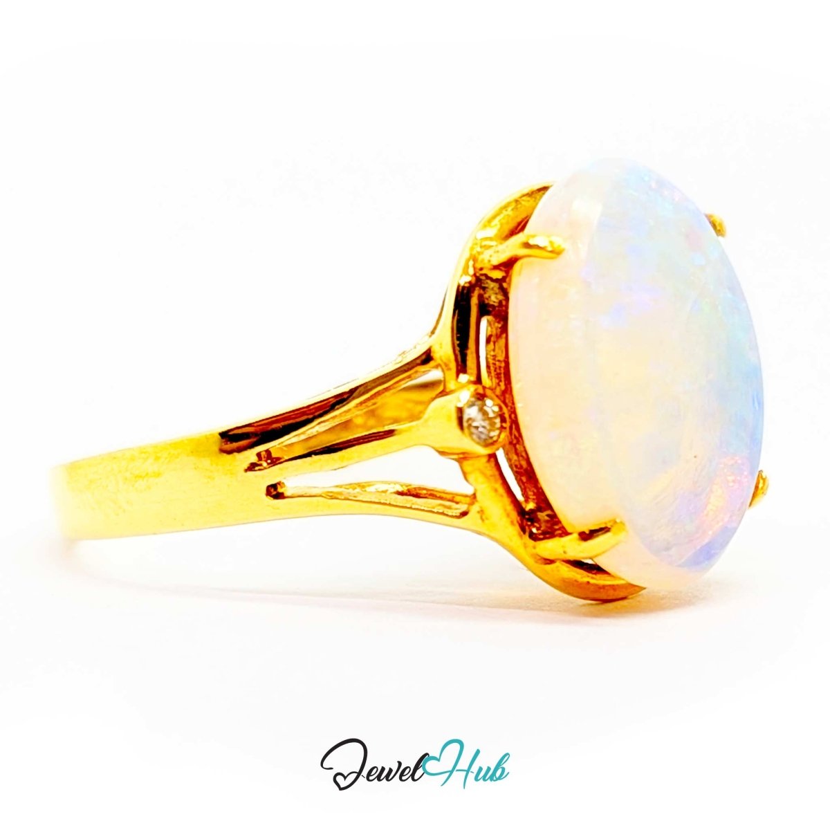 A 18k yellow gold ring featuring a large oval white opal gemstone with a small inset diamond, set against a plain white background with a 'JewelHub' watermark at the bottom.