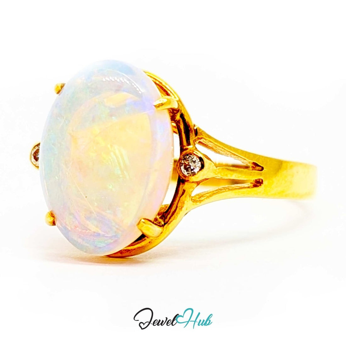 A 18k yellow gold ring featuring a large oval cabochon opal with iridescent white, blue, and yellow flashes, accented by two small round-cut diamonds on the shoulders, set against a plain white background.