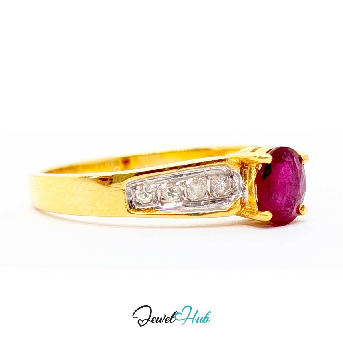 A yellow 14k gold ring featuring a large oval-cut deep pinkish-red ruby center stone and a channel-set row of clear diamonds on the band, shown against a plain white background with a 'JewelHub' watermark at the bottom.