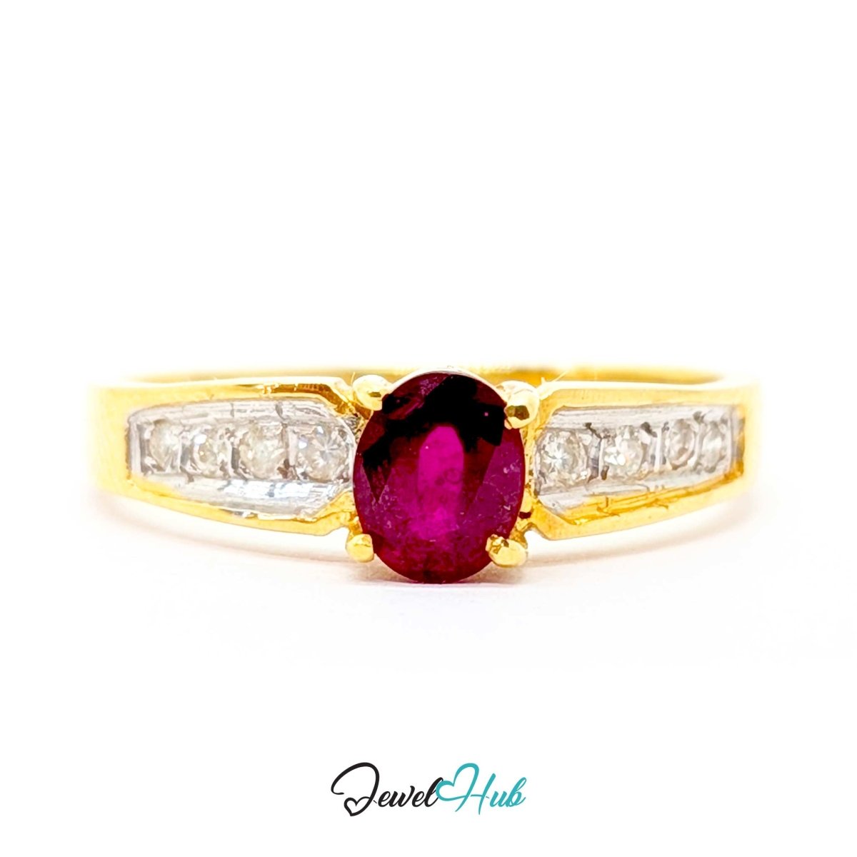 A yellow 14k gold ring featuring an oval-cut deep pinkish-red ruby center stone, flanked by rows of small clear stones on the shoulders, shown against a plain white background with a 'JewelHub' watermark at the bottom.