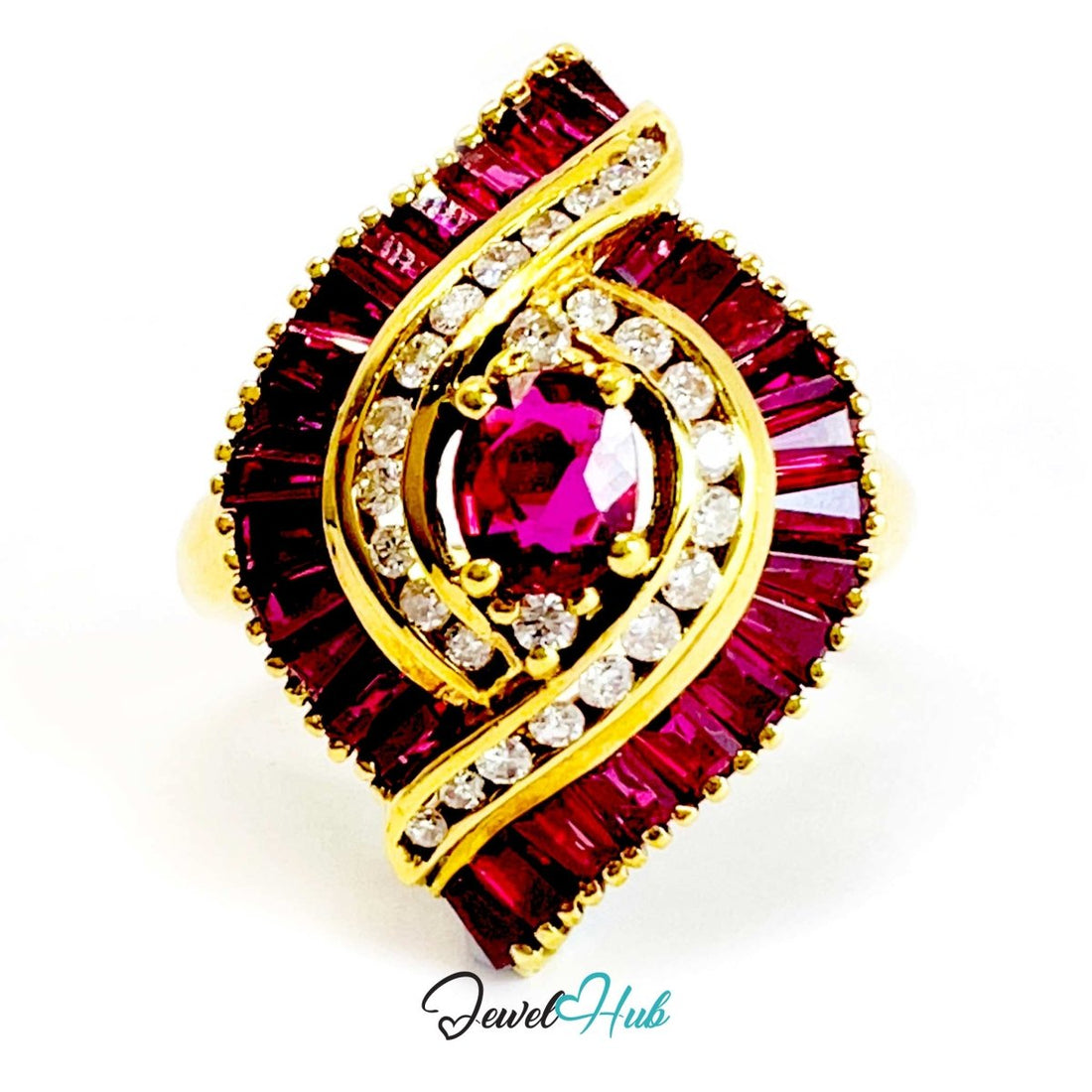 A 18k gold ring featuring a central round magenta gemstone surrounded by clear stones and bordered by deep red baguette-cut stones, shown on a white background with a JewelryHub watermark.