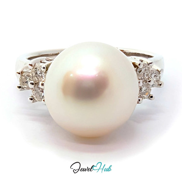 A white freshwater pearl ring with a white gold band accented by small clear gemstones on each side, shown on a white background with a 'JewelHub' watermark at the bottom.