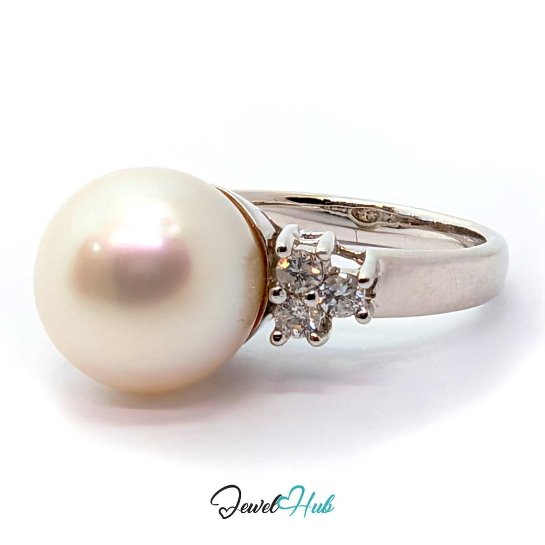 A white freshwater pearl ring with a white gold band accented by small clear gemstones on each side, shown on a white background with a 'JewelHub' watermark at the bottom.