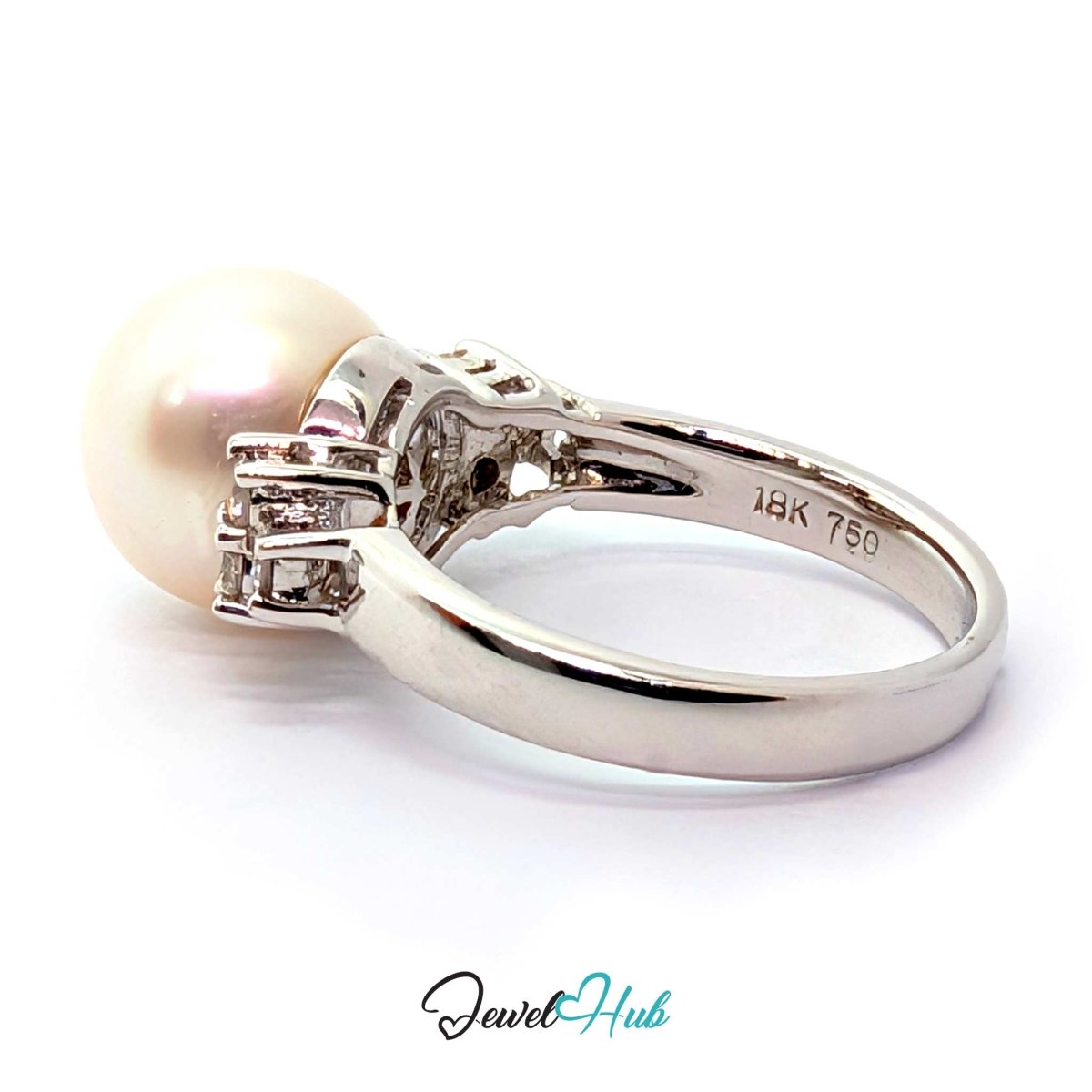 A white gold or platinum ring featuring a single lustrous pearl and small clear accent stones, shown on a clean white background with a JewelryHub watermark.