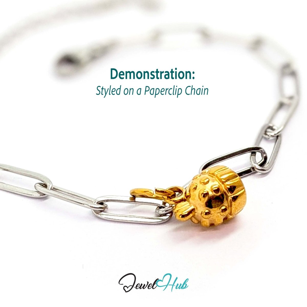 Three-dimensional cupcake charm in gold stainless steel - styled on a silver paperclip chain bracelet - JewelHub
