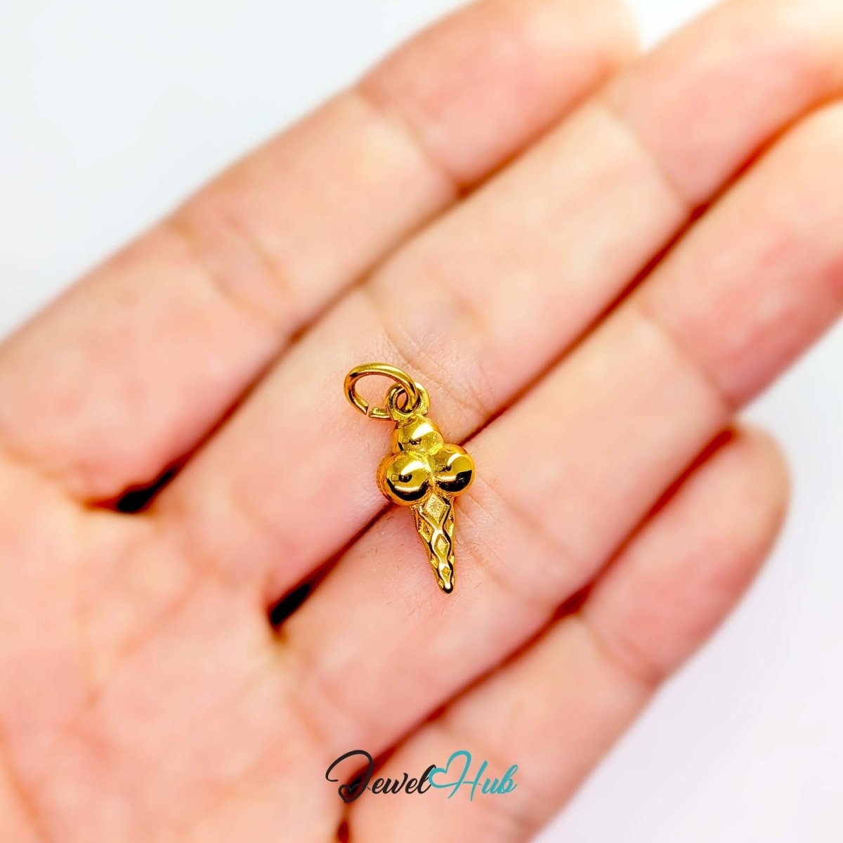 Ice cream cone charm in gold stainless steel - held in the hand for scale - JewelHub
