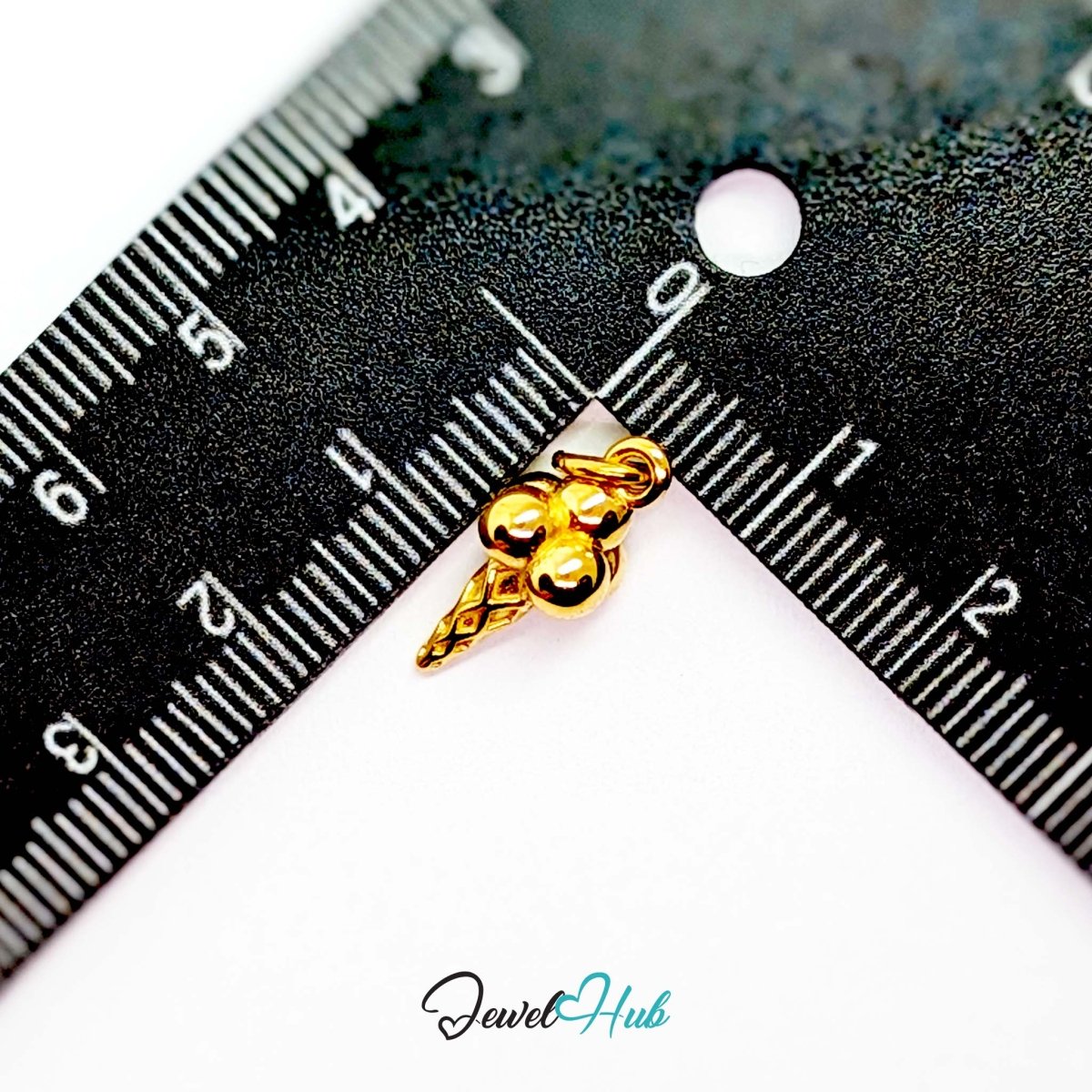 Ice cream cone charm in gold stainless steel - beside a ruler for scale - JewelHub