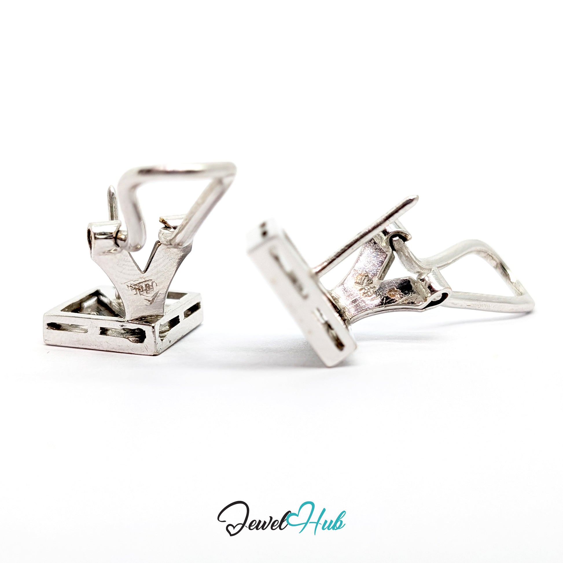 Close view of round brilliant diamonds seated in pointed lozenge recesses in 14k white gold