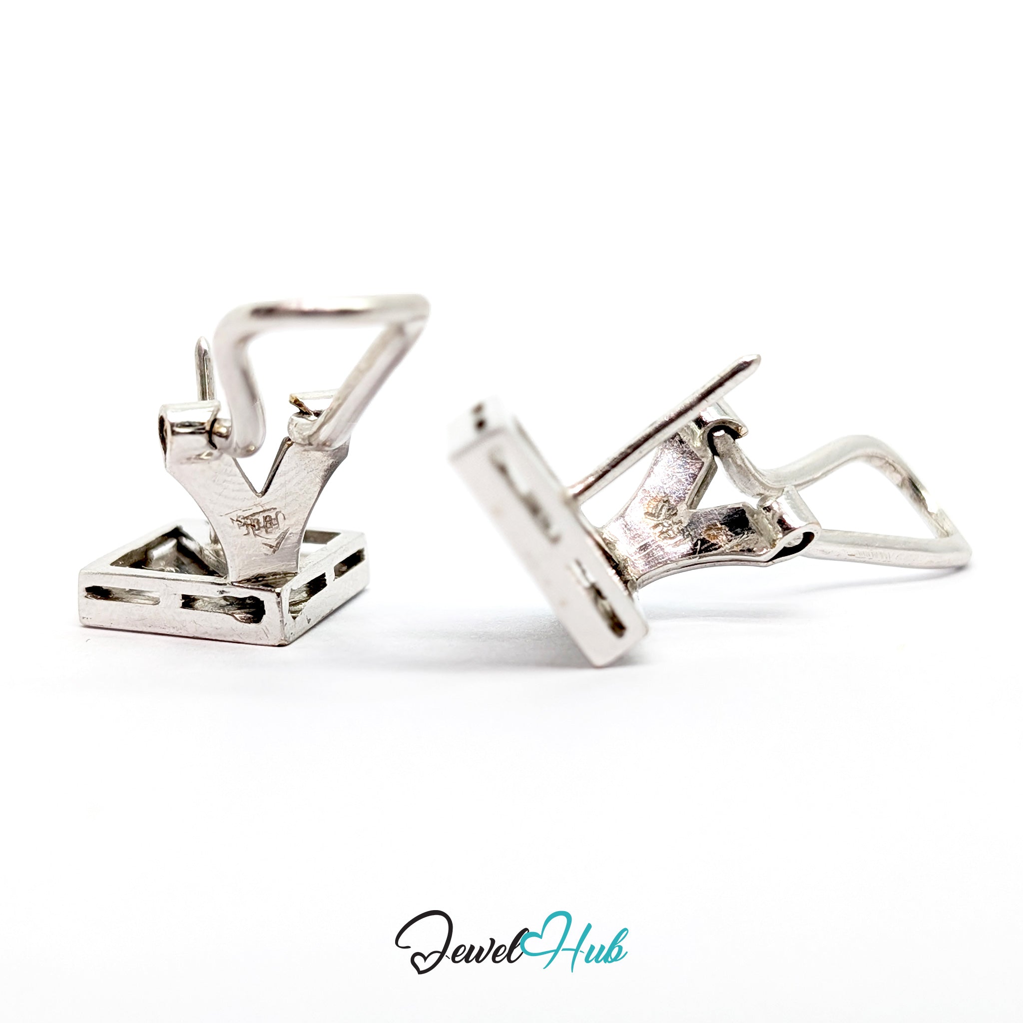 Close view of round brilliant diamonds seated in pointed lozenge recesses in 14k white gold