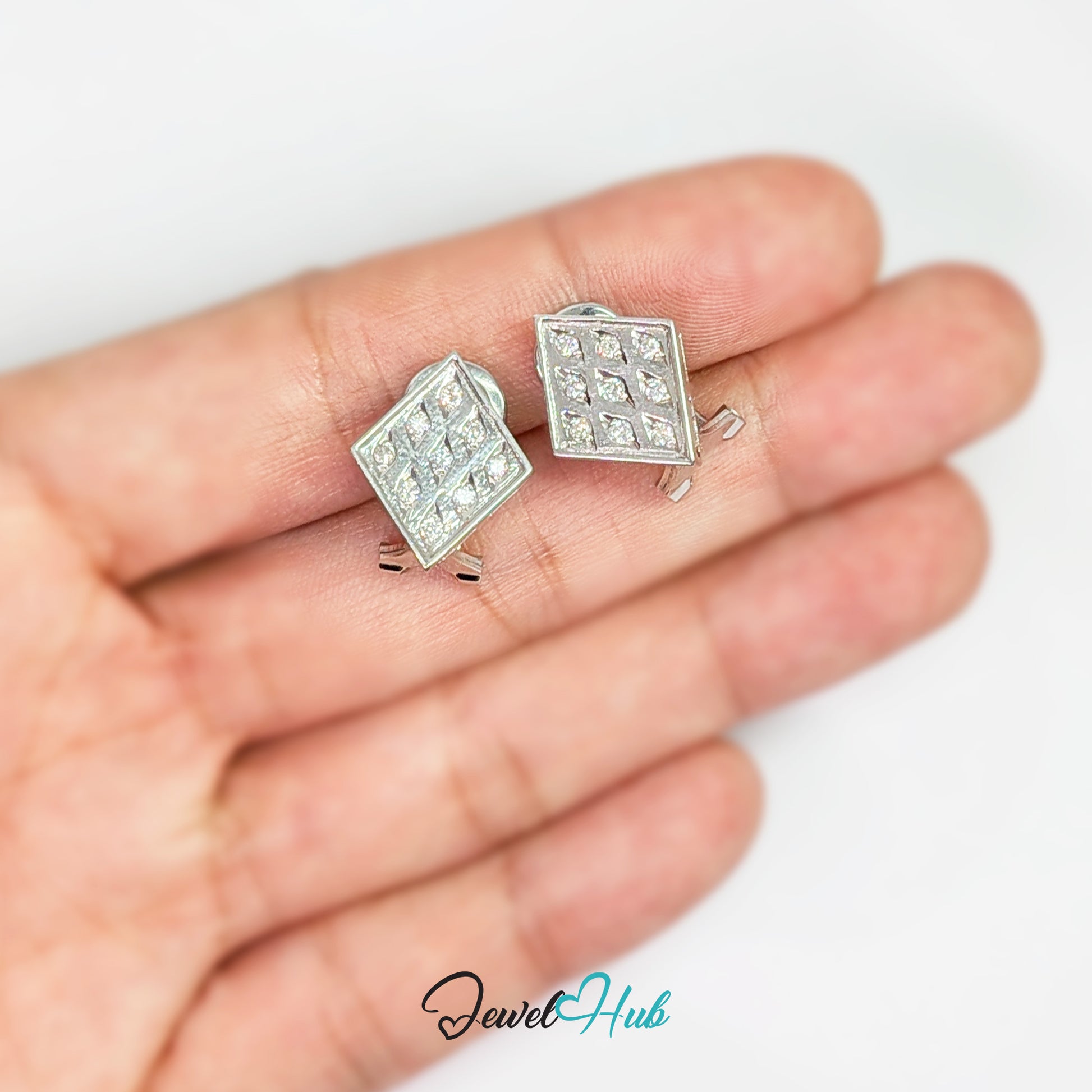 14k white gold checker diamond earrings shown in the hand for scale