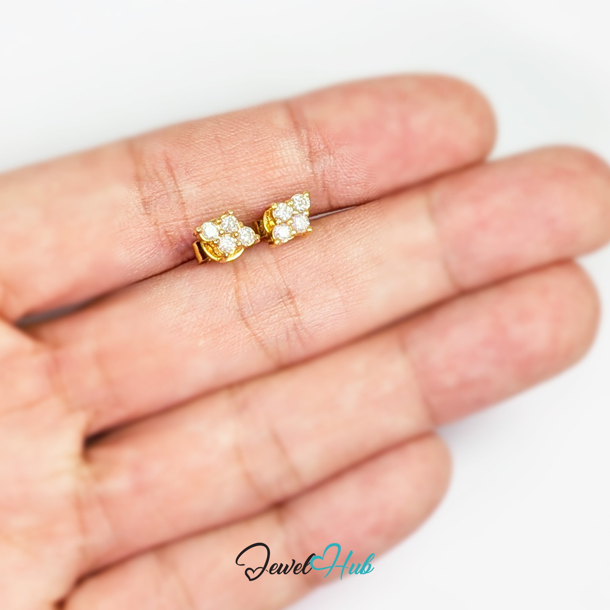 Luna Spark 14k gold diamond studs shown in the hand for scale