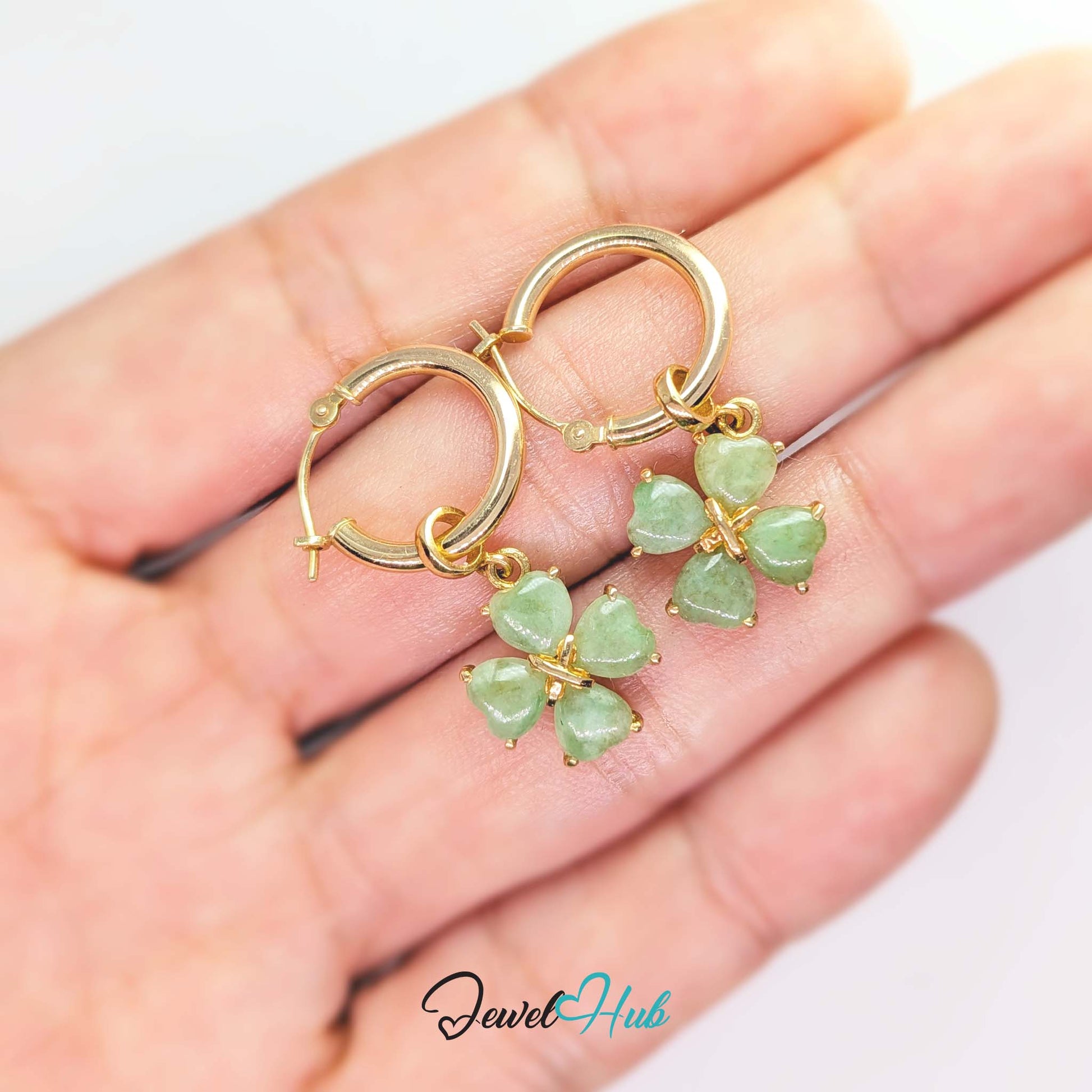 Four heart-shaped jade cabochons claw-set around a small gold cross at the centre - JewelHub